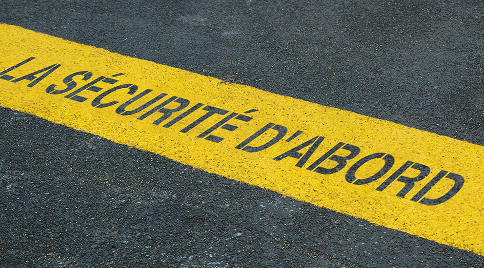 Chaussée et bande jaune avec le slogan « la sécurité avant tout »